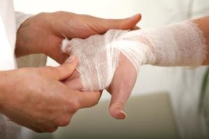 Person holding another person's bandaged hand