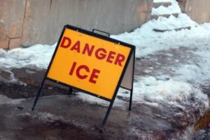 "Danger Ice" sign on a snowy sidewalk