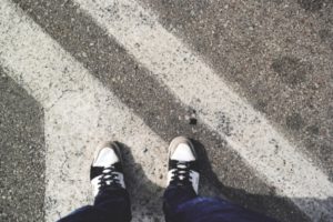 Top-down shot of a person's feet standing on the pavement