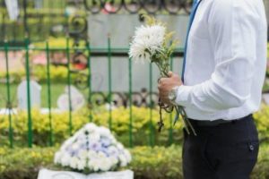 man holding flowers at funeral