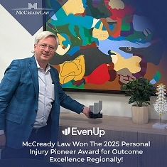Man in a blue blazer holds a trophy beside a colorful abstract painting and a small plant. Text highlights award details.