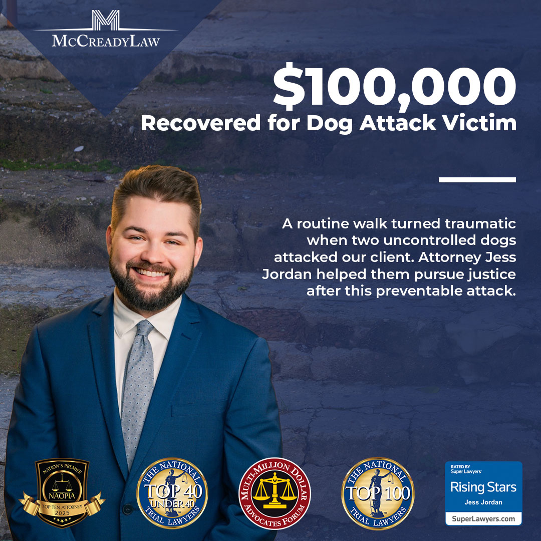 $100,000 recovered for a dog attack victim. Attorney Jess Jordan smiles in a suit, with awards displayed beside him.